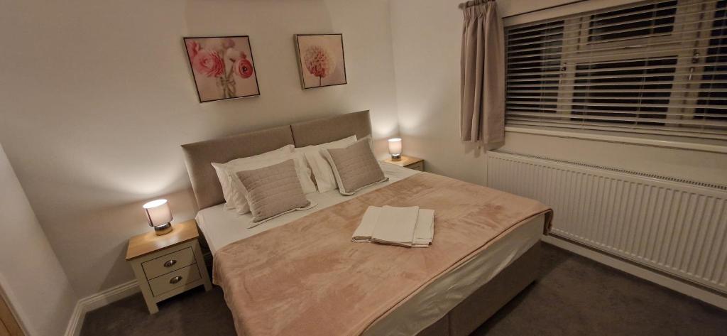 a bedroom with a bed with two lamps on it at Terling House in Hythe