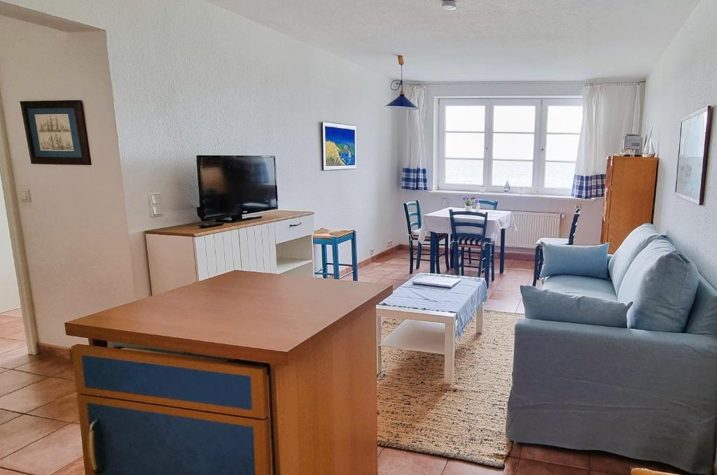 a living room with a couch and a table at Ferienwohnung Soling - ideal für Paare, mit Wasserblick in Alt Reddevitz
