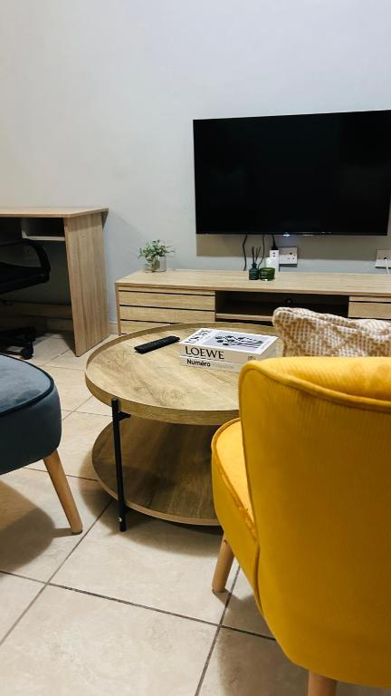 a living room with a table and chairs and a tv at DL Apartments in Palatswe