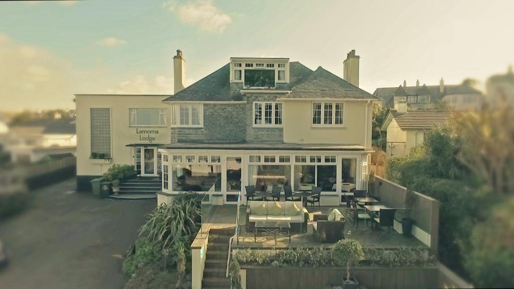 una grande casa bianca con sedie e tavoli di fronte di Lamorna Lodge a St Ives