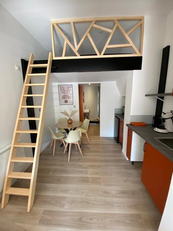 a room with a loft bed and a dining room at La Cabane Perché in Ault