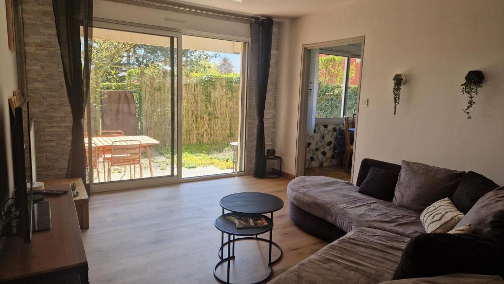 a living room with a couch and a table at Les Hautains in Saint-Genis-Pouilly