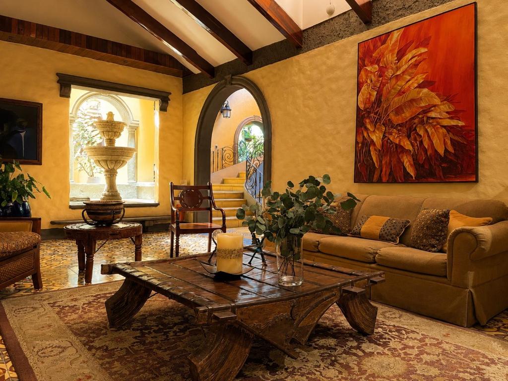 a living room with a couch and a table at Hotel 1915 INN & SUITES in Alajuela