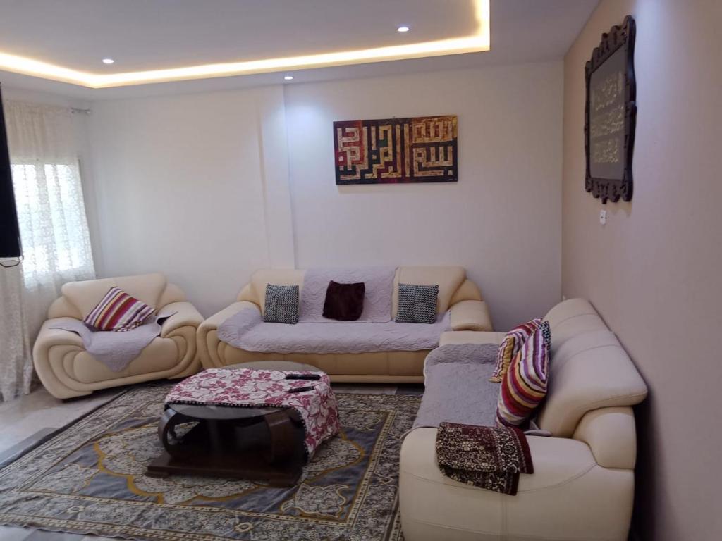 a living room with two couches and a rug at Résidence Rahma in Hammam Chott