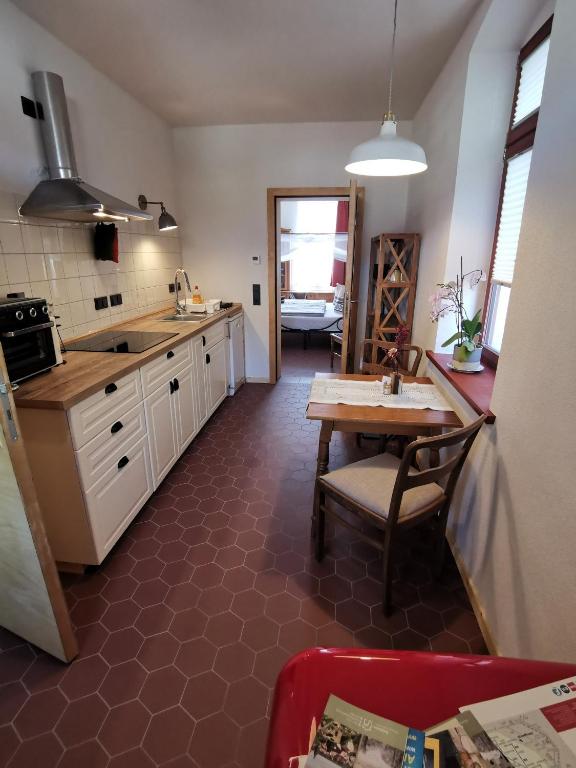 a kitchen with a table and a sink and a dining room at Vielstubenhaus - FeWo August in Pirna
