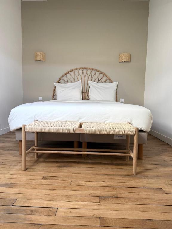 a large bed with a bench in a bedroom at Le Clos Langevin in Épernay