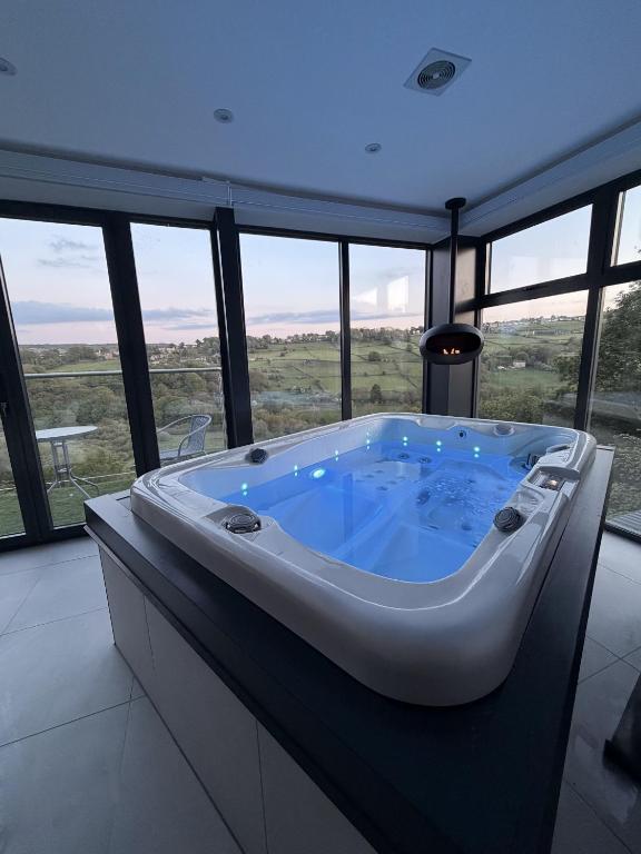 a large bath tub in a room with windows at Woodroyd Spa Suites in Luddenden Foot