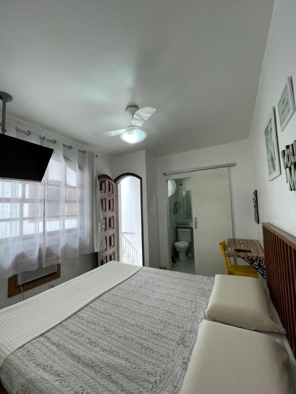 a bedroom with a large bed and a bathroom at Suíte da Fran - Perto da UFF in Niterói