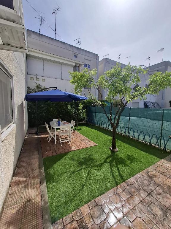 a patio with a table and a blue umbrella at La casa del delfino in Policoro