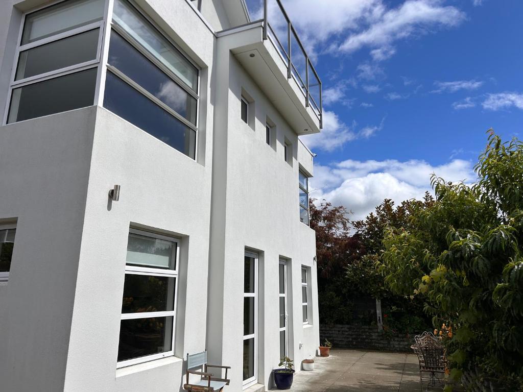 a white building with a balcony on the side of it at Cbay 1 Bedroom Suite in Timaru
