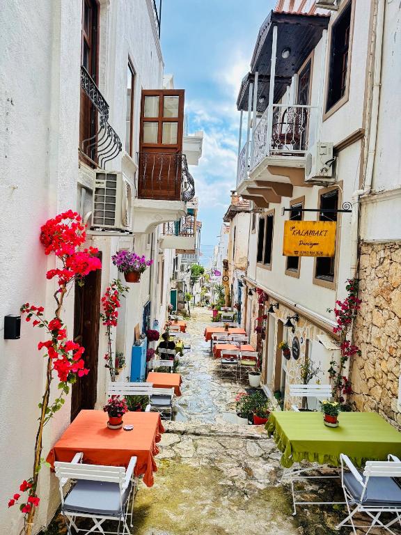 a narrow street with tables and chairs in a town at Old Kalamaki Pansiyon in Kalkan