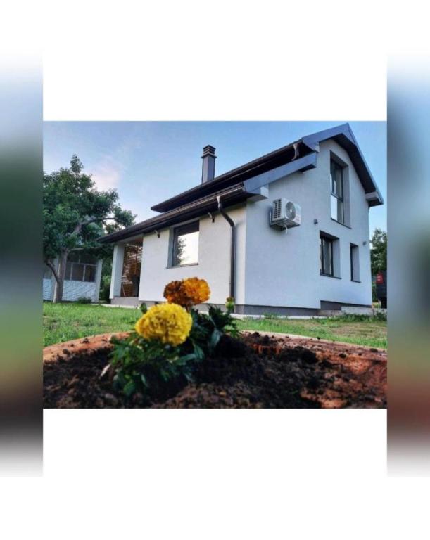 a white house with some flowers in a yard at House For Rest VIN in Kolašin