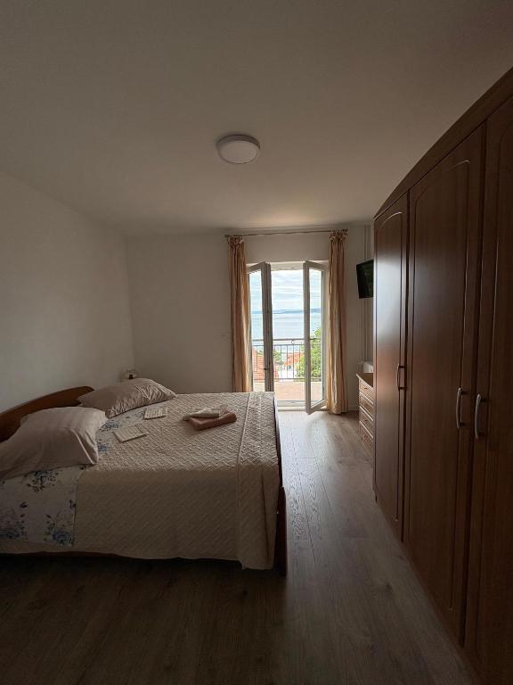 a bedroom with a bed and a sliding glass door at Rooms Raos in Brela