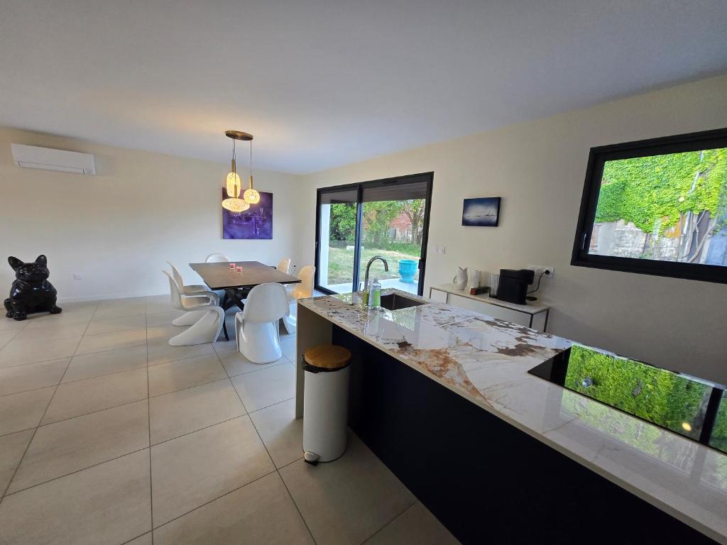 a kitchen with a counter and a dining room at VILLA du VERNET avec JACUZZI in Vernet