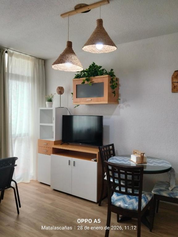 a living room with a tv and a table with chairs at Estudio DUNA BLANCA in Matalascañas