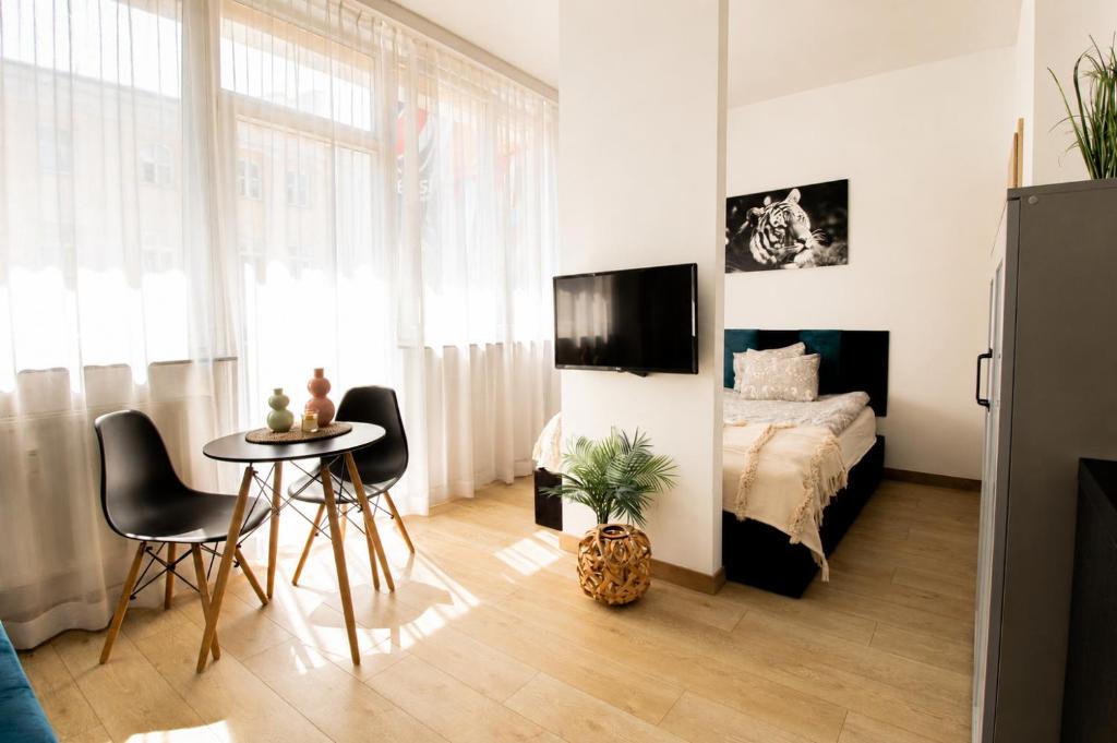 a bedroom with a bed and a table and chairs at PiotrApartments - Central Warsaw Wilcza - Luxury Apartment - Prime Location in Warsaw