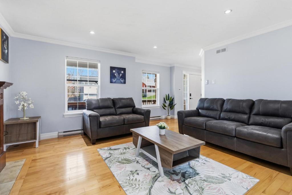 a living room with a couch and a table at Spacious 4BR Family Retreat w- Game Room 10p in Dieppe