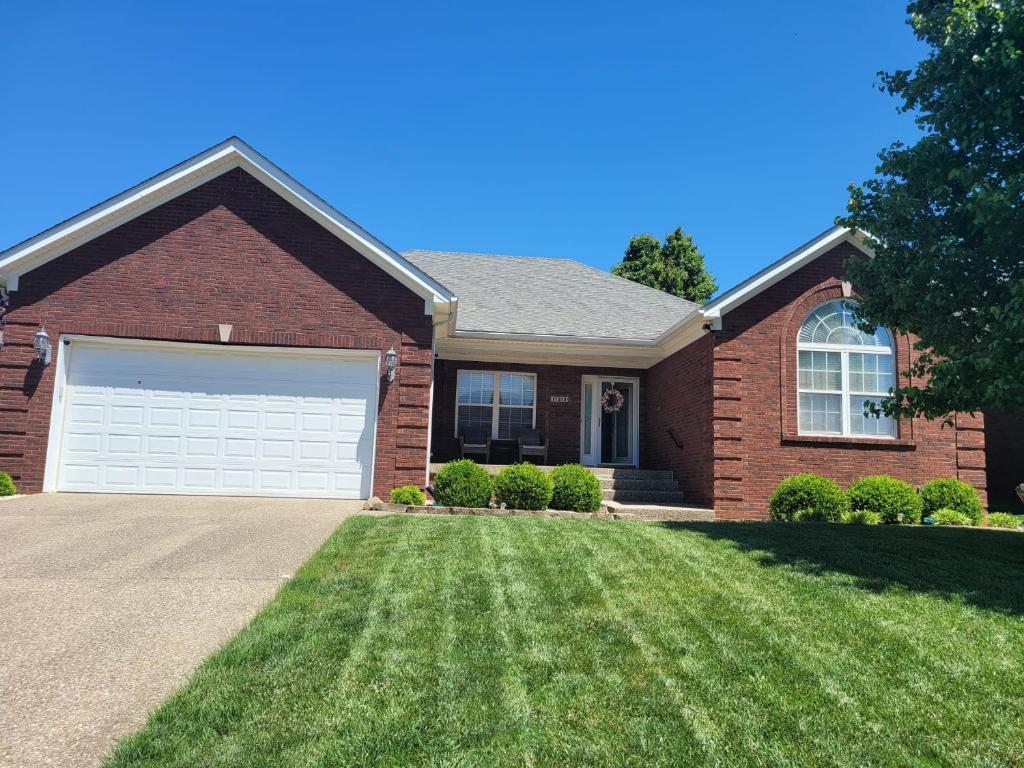 a brown brick house with a white garage at Blessings Private Home in Louisville