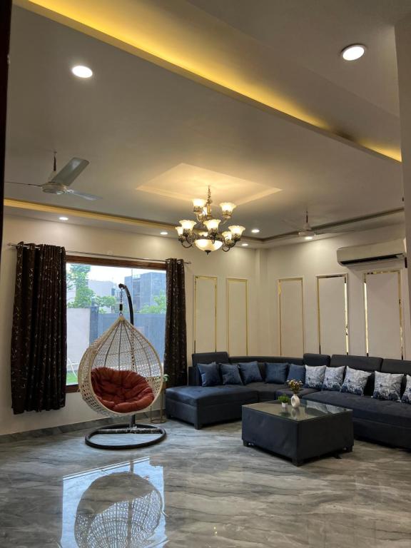 a living room with a blue couch and a chair at Aura Villa in Ghaziabad