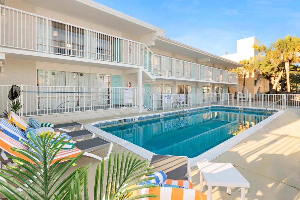 a swimming pool in front of a building at Fin's Inn & Suites in Myrtle Beach