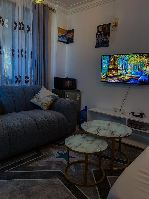 a living room with a couch and two tables at Imastay in Mombasa