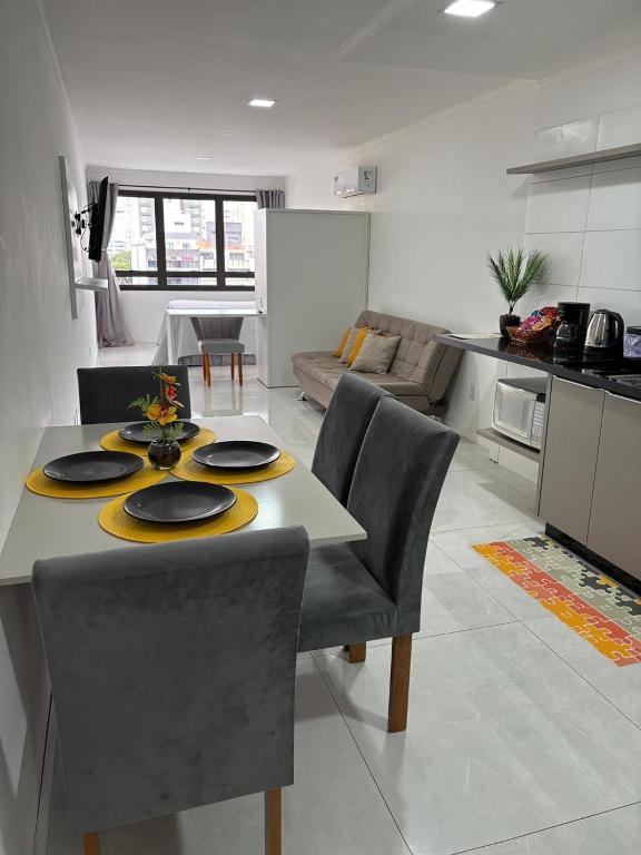 a kitchen and living room with a table and chairs at Loft moderno e completo a 200m do Consulado Americano in Porto Alegre