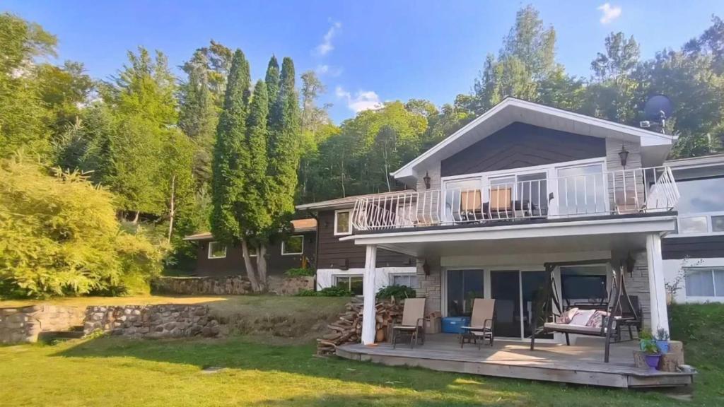 a house with a balcony and a yard at Chalet l'Apero in Val-des-Bois