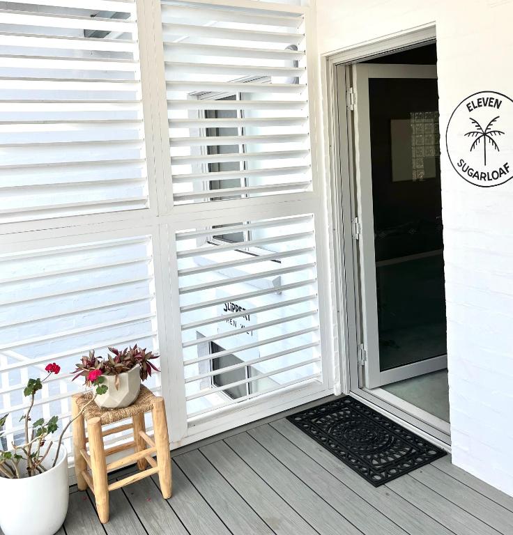 a sliding glass door on a porch with plants at Blueys Motel in Blueys Beach