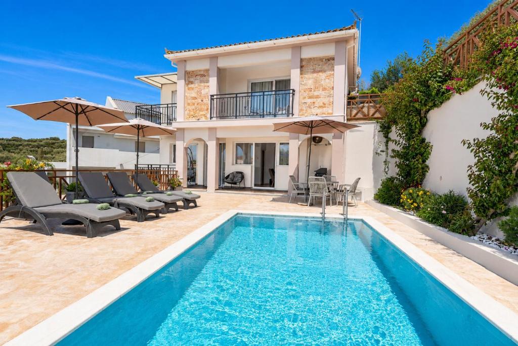 a villa with a swimming pool in front of a house at Villa Naisy in Tsilivi