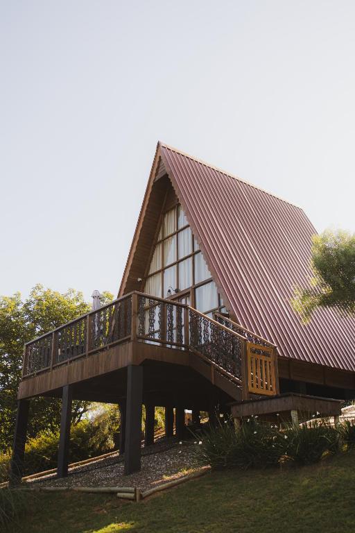 a large wooden house with a large deck at Refúgio Suiço em Vargem Alta in Vargem Alta