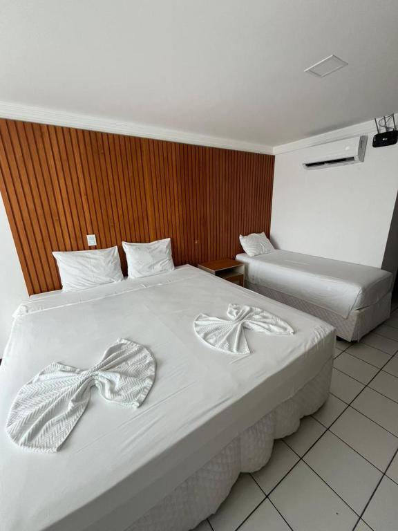 a hotel room with two beds with bows on them at Ponta Negra Flat 305 in Natal
