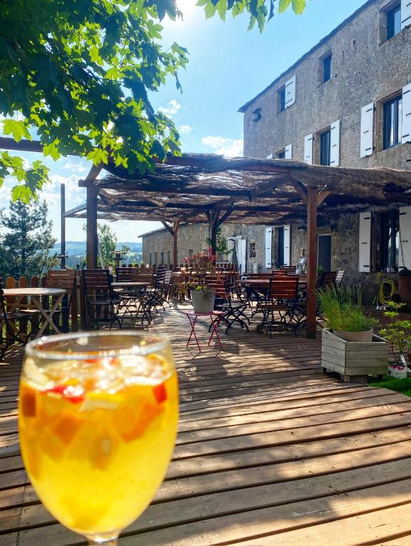 a glass of orange juice sitting on a wooden deck at La Bastide en Margeride in Châteauneuf-de-Randon