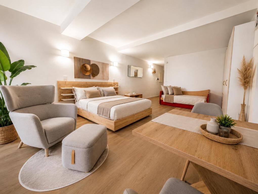 a bedroom with a bed and a couch and a table at TIMELESS HOME Deluxe Cinema Suite in Parma