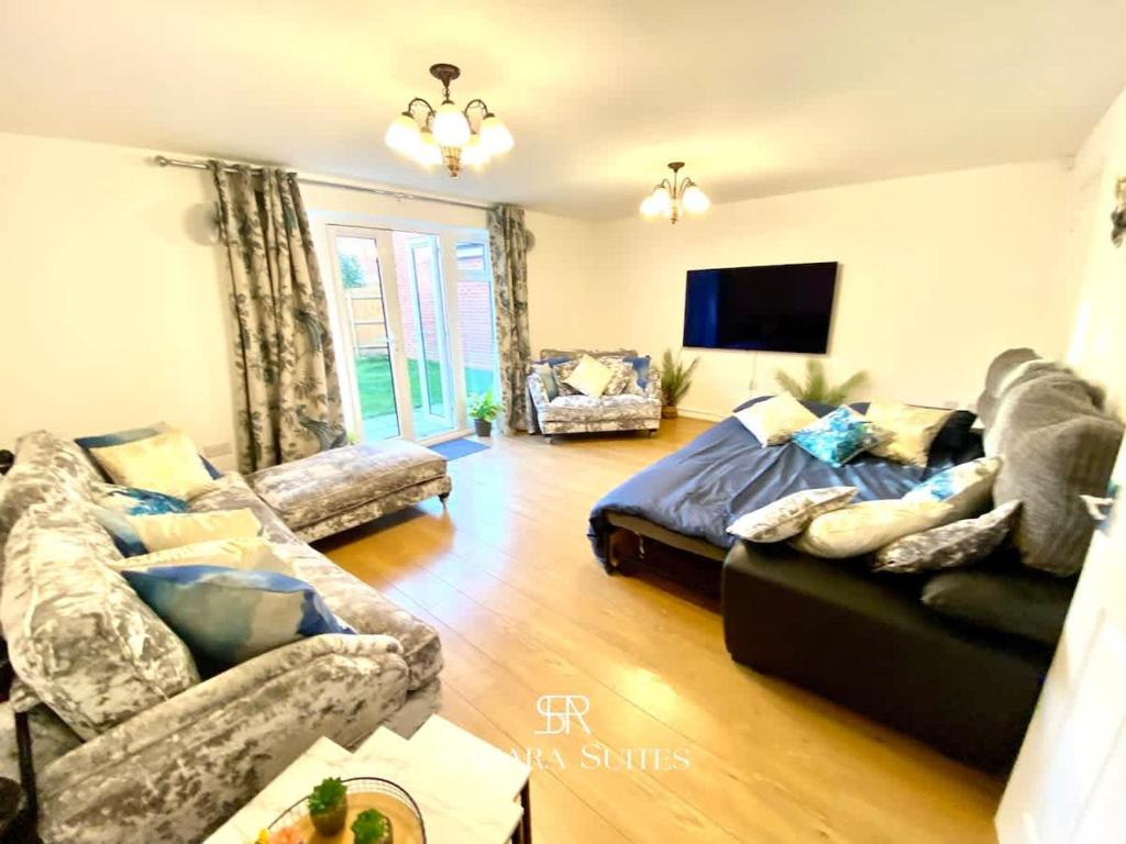 a living room with a bed and a couch at 4 Bed House with Driveway Parking for 2 Cars - Rugby - Sleeps 10! Perfect for groups! in Rugby