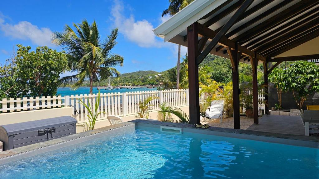 a swimming pool in front of a house at Bibi Beach Sunrise in La Trinité