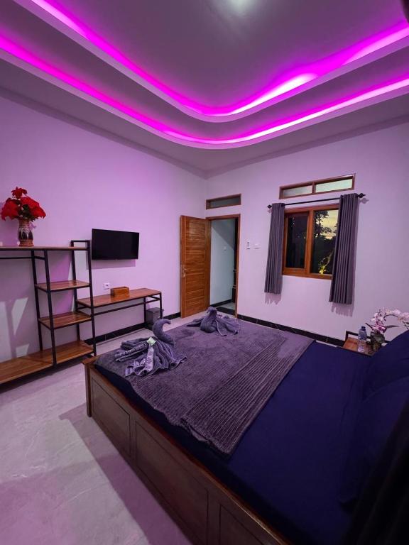 a bedroom with a large bed with purple lighting at Penginapan Angsoka 1 in Singaraja