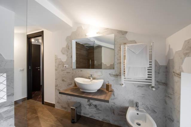um banheiro com uma pia e um espelho em B&B Glicini em Roma