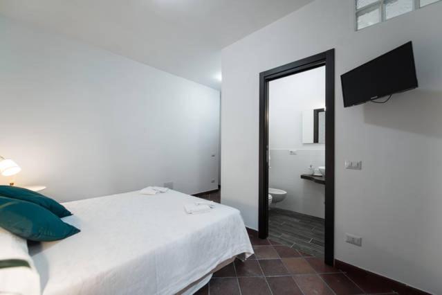 um quarto com uma cama e uma casa de banho com um espelho. em B&B Glicini em Roma