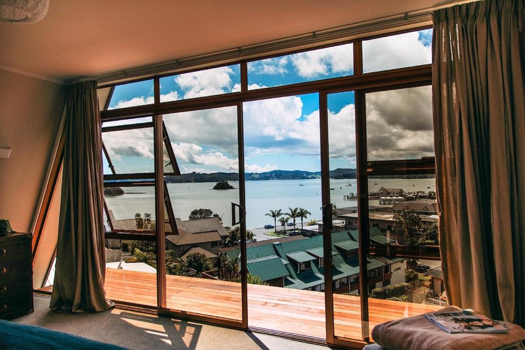 a room with a large window with a view of the water at Moana View in Paihia