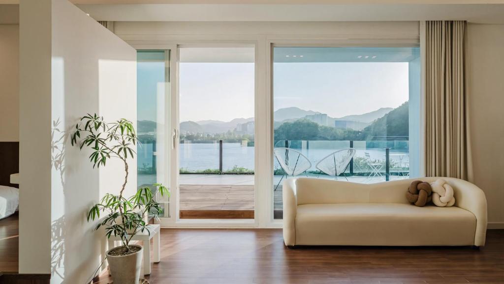 a living room with a couch and a large window at Chuncheon Rehouse in Chuncheon