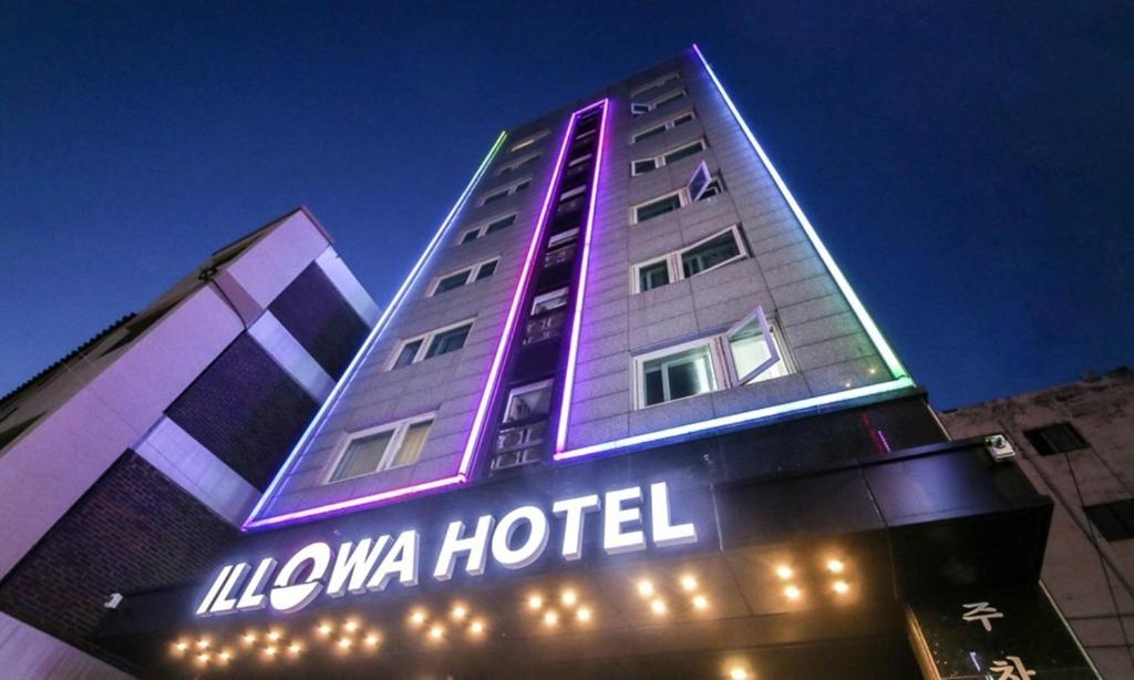 a hotel building with a neon sign on it at Anyang ILLOWA Hotel in Anyang
