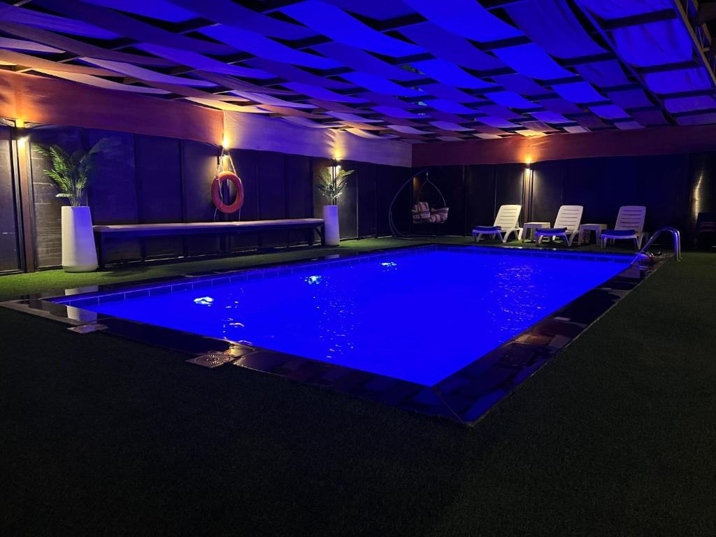 a swimming pool with blue lighting in a room at Tuscany Villa Jarash in Al Madwar