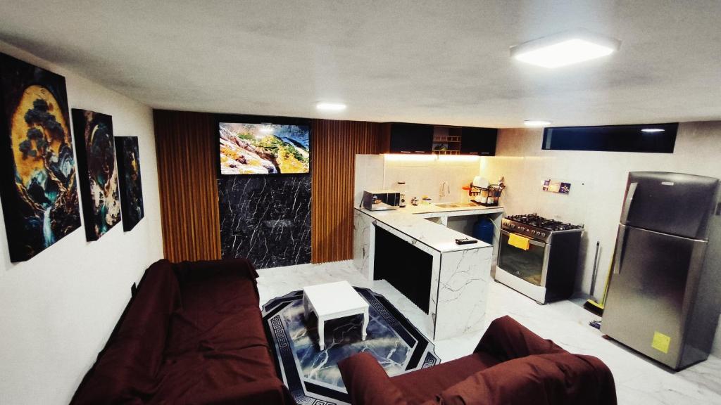 a kitchen with a refrigerator and a counter top at Departamento Confortable in Latacunga