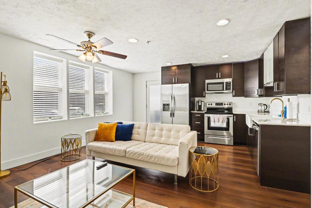 a living room with a couch and a kitchen at Downtown Omaha - Elevated Studio & 1-Bed Stays in Omaha