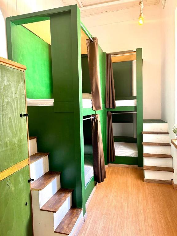 a room with two bunk beds and a green wall at Cocos Hostel Rio in Rio de Janeiro