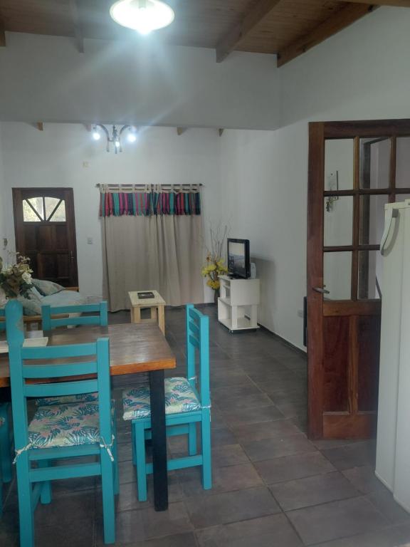 a dining room with a table and blue chairs at Quinta Los Sauces in Nueve de Julio