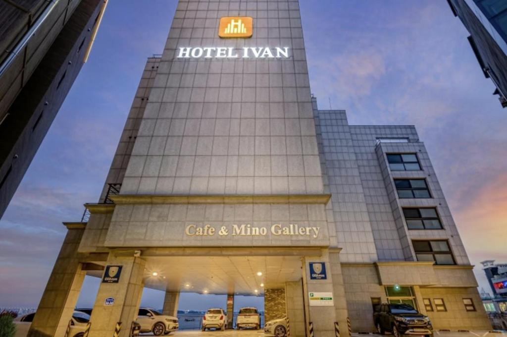 a building with cars parked in front of it at Dangjin Hotel IVAN in Dangjin