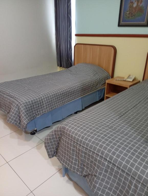 two beds sitting next to each other in a room at Carica homestay in Surabaya