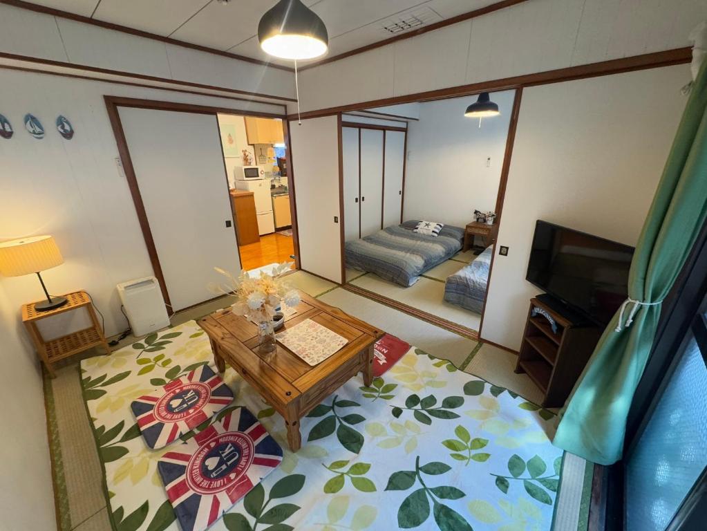 a living room with a table and a couch at Green Hights Residence-106 in Naha