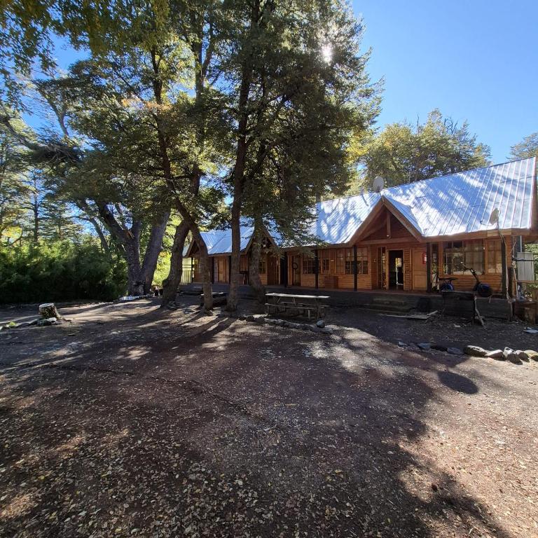 a large wooden house with a tree in front of it at Lodge De Ñuble in Las Trancas